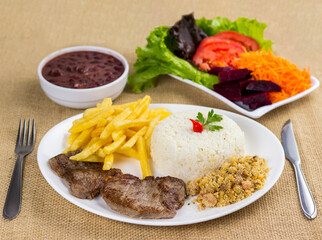 Typical Brazilian food, executive dish, food menu. Beef, rice, beans, potato and crumbs with accompaniments