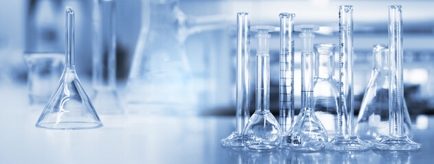 glass flask and cylinder in soft blue light medical science laboratory banner background