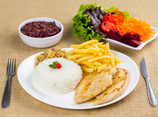 Typical Brazilian food, executive dish, food menu. Chicken breast, rice, beans, potato and crumbs with accompaniments
