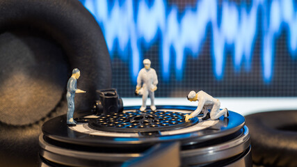 Miniature people : Close up engineer checks the sound quality of the headphone