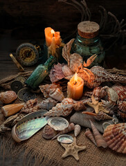 seashells, candle, old bottle on grunge wooden background. pirates and adventure, vintage composition. sea travel and vacation concept