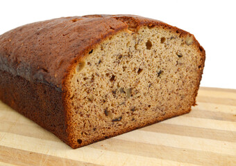A fresh homemade loaf of banana walnut bread on wooden board