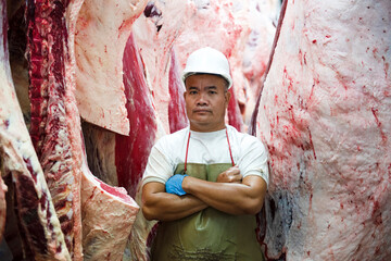 A professional butcher in the factory's cold storage with the carcass of Japanese Wagyu beef in the...