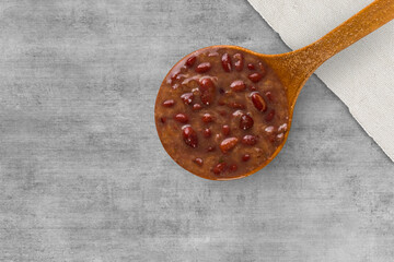 A spoon with Brazilian Feijoada Food. Top view. wooden table background. Copy sapce