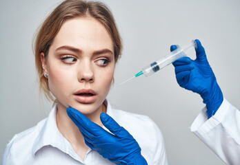 Woman syringe anesthesia botox injection doctor blue gloves