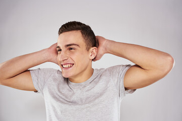 Man in a white t-shirt emotions gestures with hands close-up cropped view light background