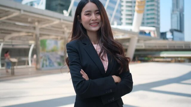 Portrait of beautiful business  woman stand with arm crossed or confidence action in big city also smiling and look to camera. Concept of successful in business support staff good working. 