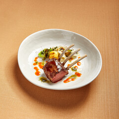 Rack of lamb in white deep plate close-up