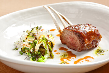 Rack of lamb in white deep plate close-up