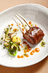 Rack of lamb in white deep plate close-up