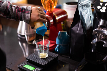Fototapeta na wymiar closeup barista pour milk into a cup in a cafe