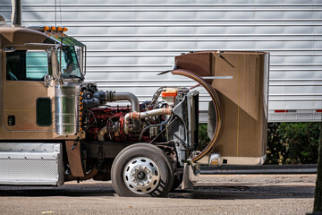 Brown big rig semi truck with open hood for checking that the engine is working properly during a...