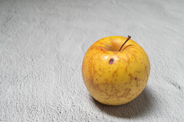 Yellow autumn organic apple autumn fruit isolated on a grey textured background
