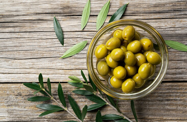Olive branches with salted olives placed on a background of old wooden planks