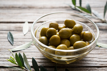 Olive branches with salted olives placed on a background of old wooden planks