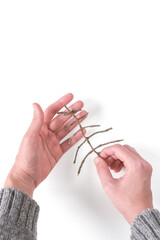 Hands holding a Christmas tree decoration made of branches. Top view, copy space.