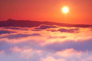 Fototapeta na wymiar 雲海と太陽。大地を覆う雲と壮大な空の風景。