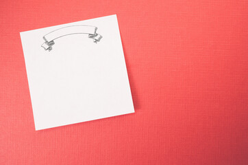 White blank memo with blank banner on a red textured surface