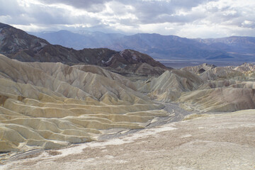 The badlands terrain of Death Valley National Park, as seen from Zabriskie Point, on a cloudy and stormy day