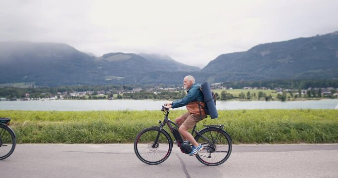 Senior pensioner couple bikers with bicycles cycling in nature, cycling trip concept.