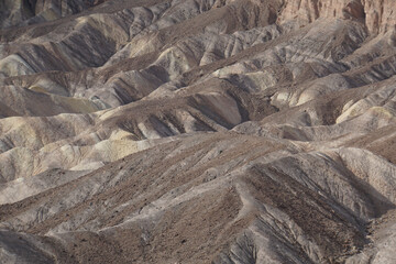 View of the lines, textures and shadows of the colorful badlands as seen from Zabriskie Point at Death Valley National Park