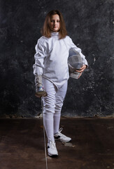 Teenage girl fencer dressed in uniform with epee and helmet