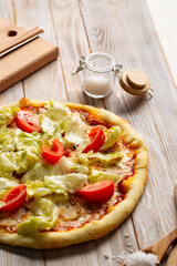 Chicken caesar pizza with tomatoes and lettuce