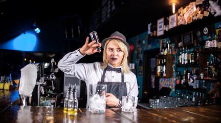 Girl bartender mixes a cocktail in the beerhall