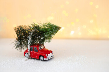 Red retro car driving a christmas tree