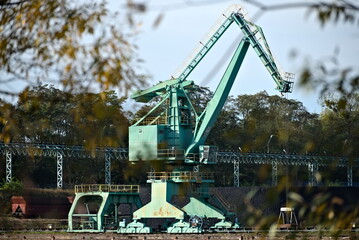 A crane on the banks of the Odra River in Szczecin. - obrazy, fototapety, plakaty