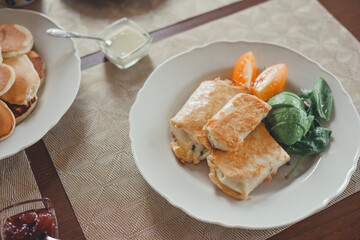 Tortillas with cheese, avocado, herbs and tomato.