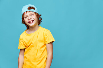 Portraits of a red-haired boy smile yellow t-shirt cap on his head joy