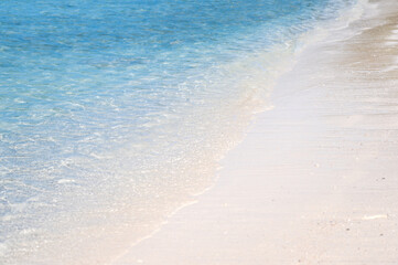 Clear sea waves and white sandy beach in summer.