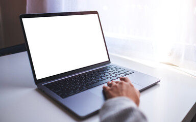 Mockup image of a businesswoman using and touching on laptop computer touchpad with blank white desktop screen on the table