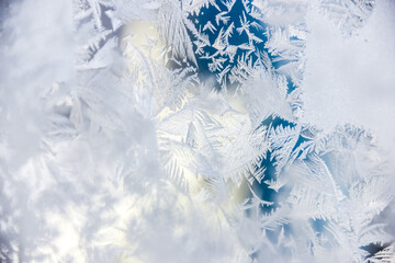 Texture of blue frost on a glass window. Frosty cold weather. White ice patterns texture close-up....