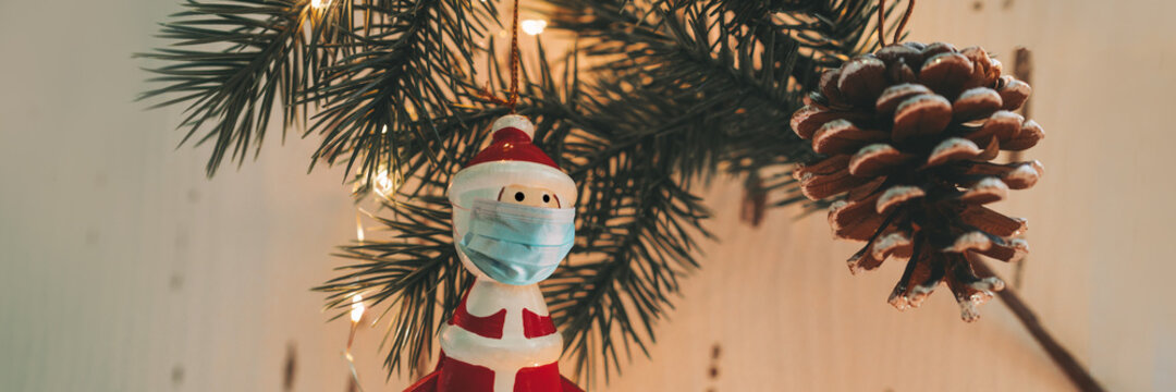 Christmas Tree Santa Claus Ornament Wearing Surgical Face Mask For Coronavirus Prevention During Holiday Family Gathering. Banner Of Social Distancing.