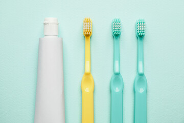 Toothbrushes and paste on color background