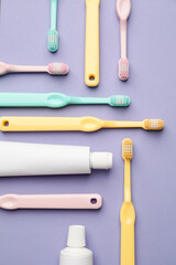 Toothbrushes and paste on color background