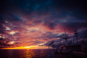 The ferry goes over the sea in the sunset