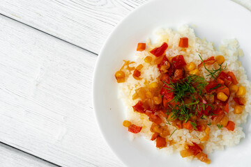 Prepared rice with vegetables on white wooden table