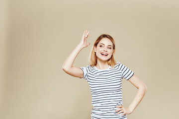 Fototapeta na wymiar Cheerful woman striped t-shirt studio beige background lifestyle emotions