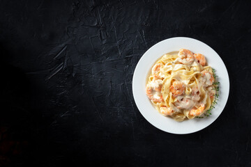Italian pasta. Pappardelle with shrimps and creamy sauce, with fresh thyme hetb, overhead shot with...