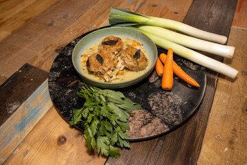 A delicious Chicken Cobbler with dumplings on a wooden kitchen work top surrounded by vegetables