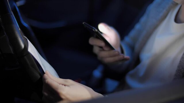 A young man scans the receipts from stores with his mobile application in his car after work. QR Code Scanning, Save Money, Deals, Coupons, Online Shopping