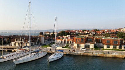 Fototapeta na wymiar Yachts docked on a small port near modern houses