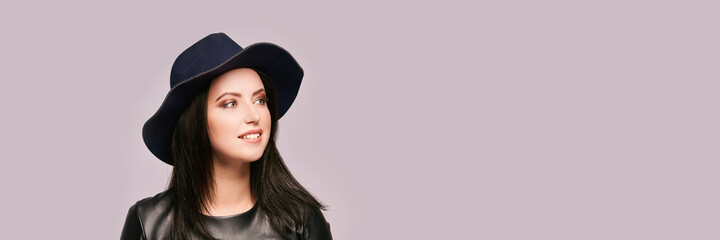 Pretty young woman at black hat. Looking side. High quality photo. Elegant female portrait. Beauty makeup. Grey background. Copyspace. Gorgeous romantic face. Perfume concept.