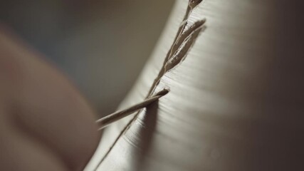 Potter paints ear of wheat on clay pot