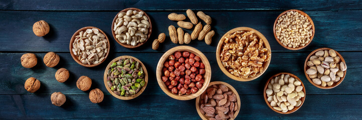 Nuts panorama. Walnuts and cashews, peanuts, and hazelnuts, almonds, pine nuts and pistachios, overhead flat lay shot