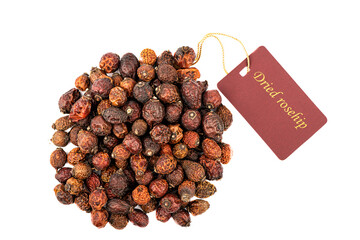 Dried rose hips with a tag isolated on a white background. The inscription on the tag Dried rose...