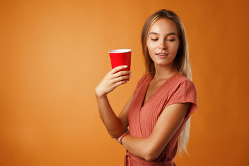 Attractive young woman standing and drinking hot drink